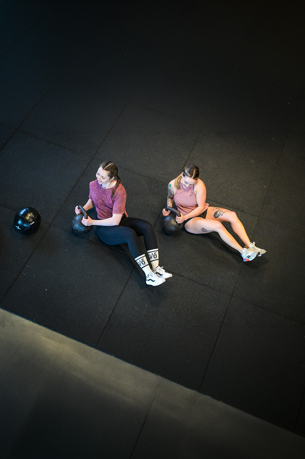 Zwei Frauen trainieren mit Kettlebells auf dem Boden der CrossFit Box bei Halle Zwo, Vogelperspektive